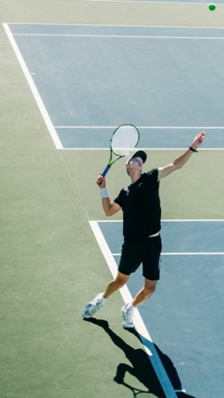a male tennis player in a black shirt is playing tennis