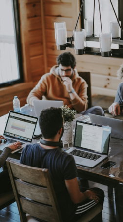 men sitting in front of their laptop computer