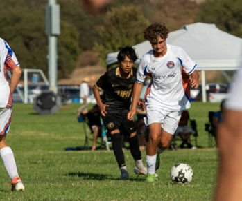 young-men-playing-soccer-on-a-grassy-field.jpg Young men playing soccer on a grassy field