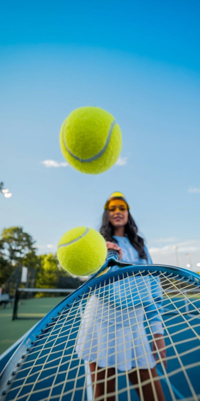 woman in black jacket and black pants holding tennis racket under blue sky during daytime